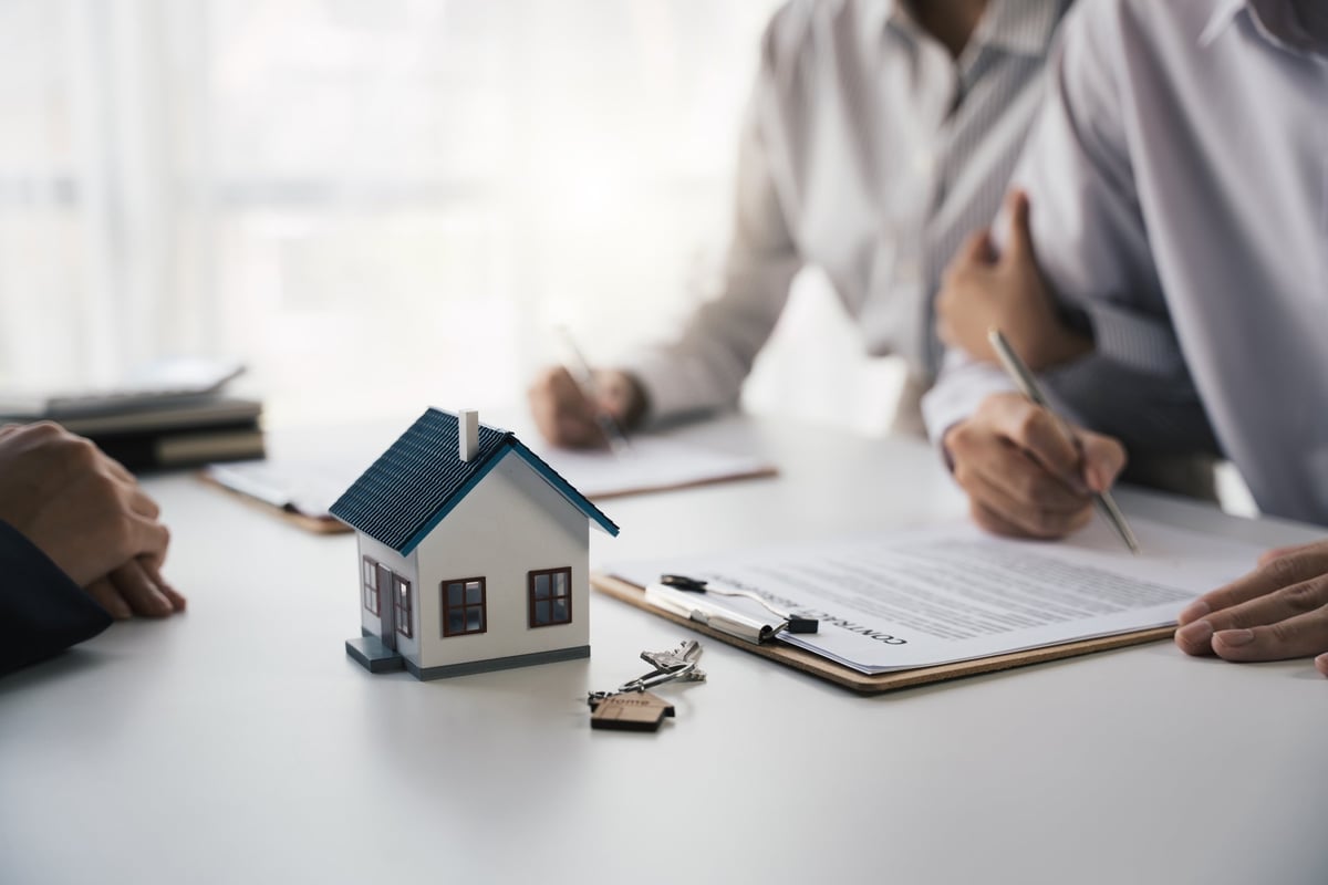 Customer writing signing signature on paper contract with real estate agent and receive sample home, Agreement to sign the purchase contract concept.